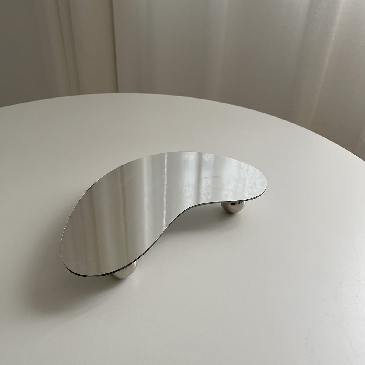 Additional view of the pebble shape acrylic footed tray.